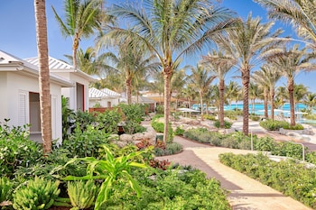 A wooden deck with palm trees and a clear blue sky. at SLS Baha Mar