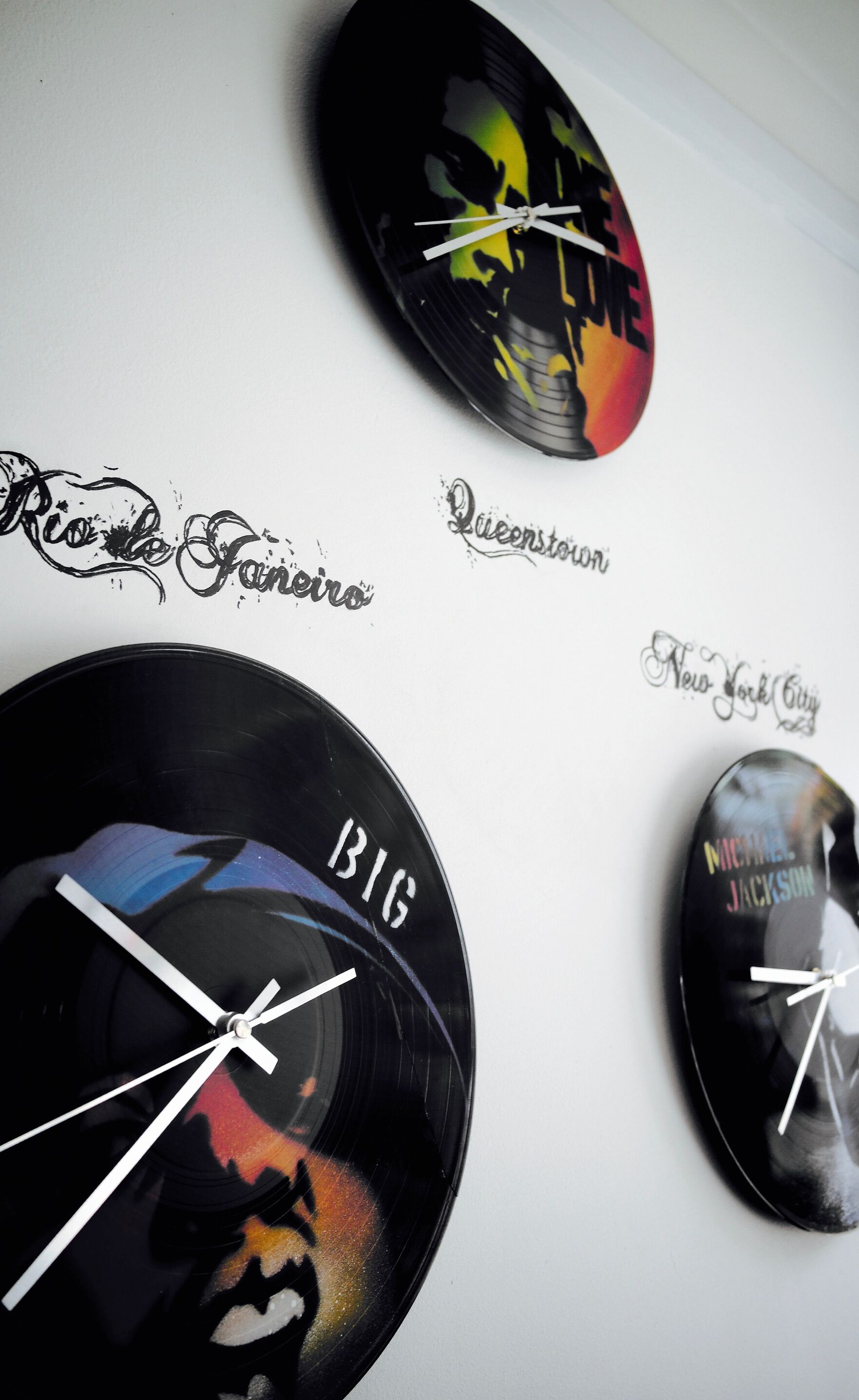 A wall with vinyl records featuring band names and cities.