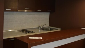 A modern kitchen with dark cabinetry, a stainless steel sink, and a gas stove.