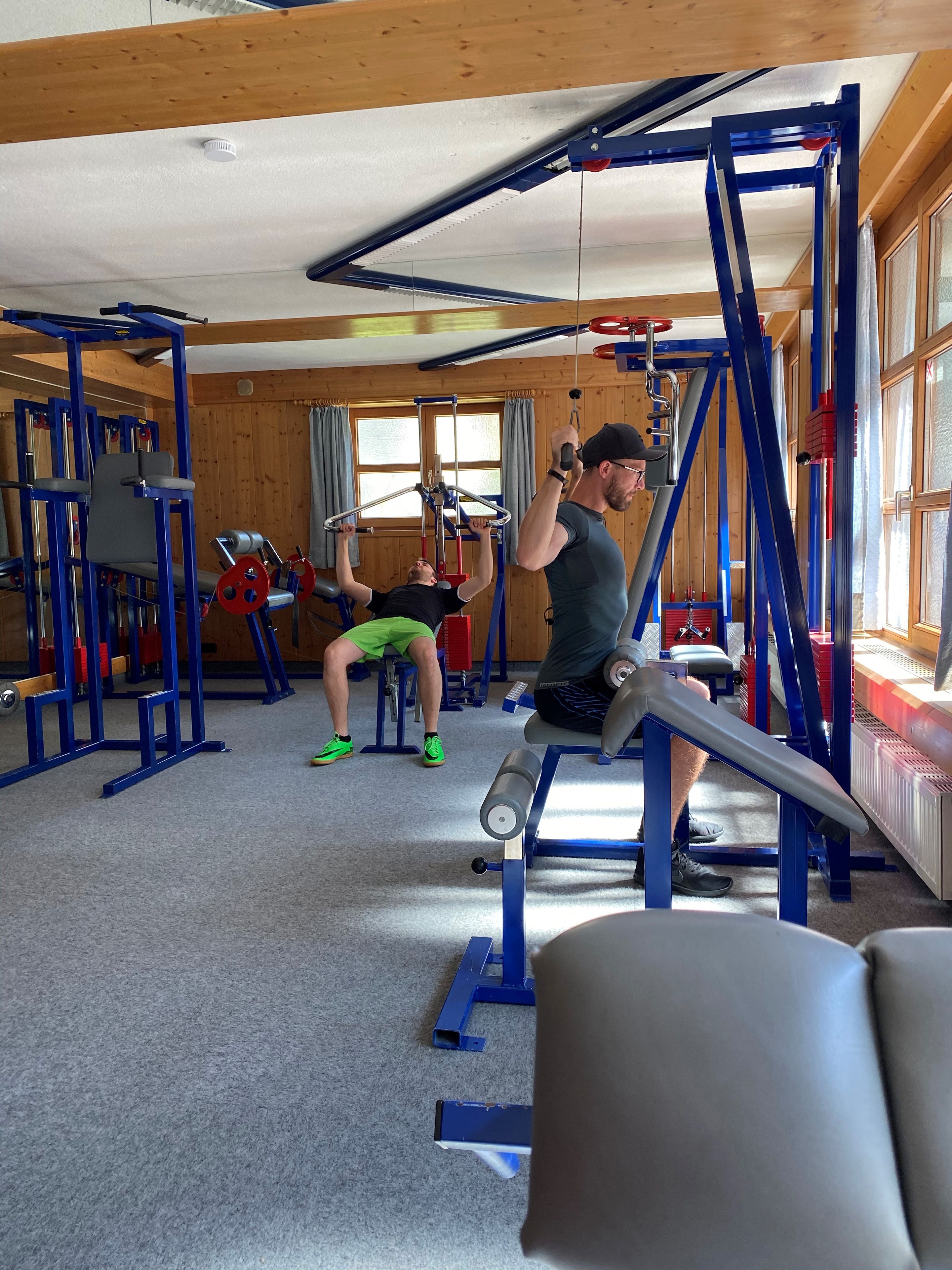 A gym with various exercise equipment, including a pull-up bar and weight machines.