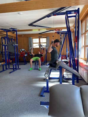 A gym with various exercise equipment, including a pull-up bar and weight machines. - Hotel Zirbenhof (Sankt Leonhard im Pitztal)