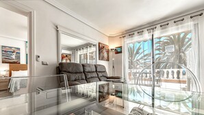 Un salon moderne avec une table basse en verre, un canapé en cuir et des œuvres d’art accrochées aux murs.