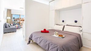 Une chambre à coucher moderne avec un grand lit, un canapé et un coin repas.