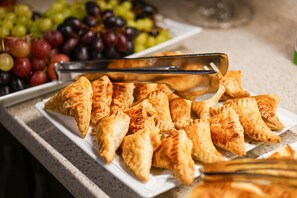 A plate of pastries and a bowl of grapes on a countertop. - Eskibağ Butik Hotel (Adalar)