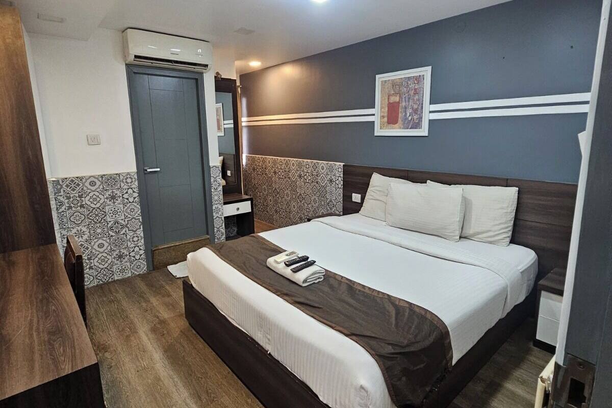 Ein Hotelzimmer mit Bett, Nachttisch und kleinem Schreibtisch.