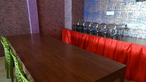 A conference room with a long wooden table and green chairs. - Aquays Hotels & Resorts (Port Blair)