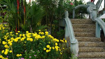 A garden with yellow flowers and a stone staircase.