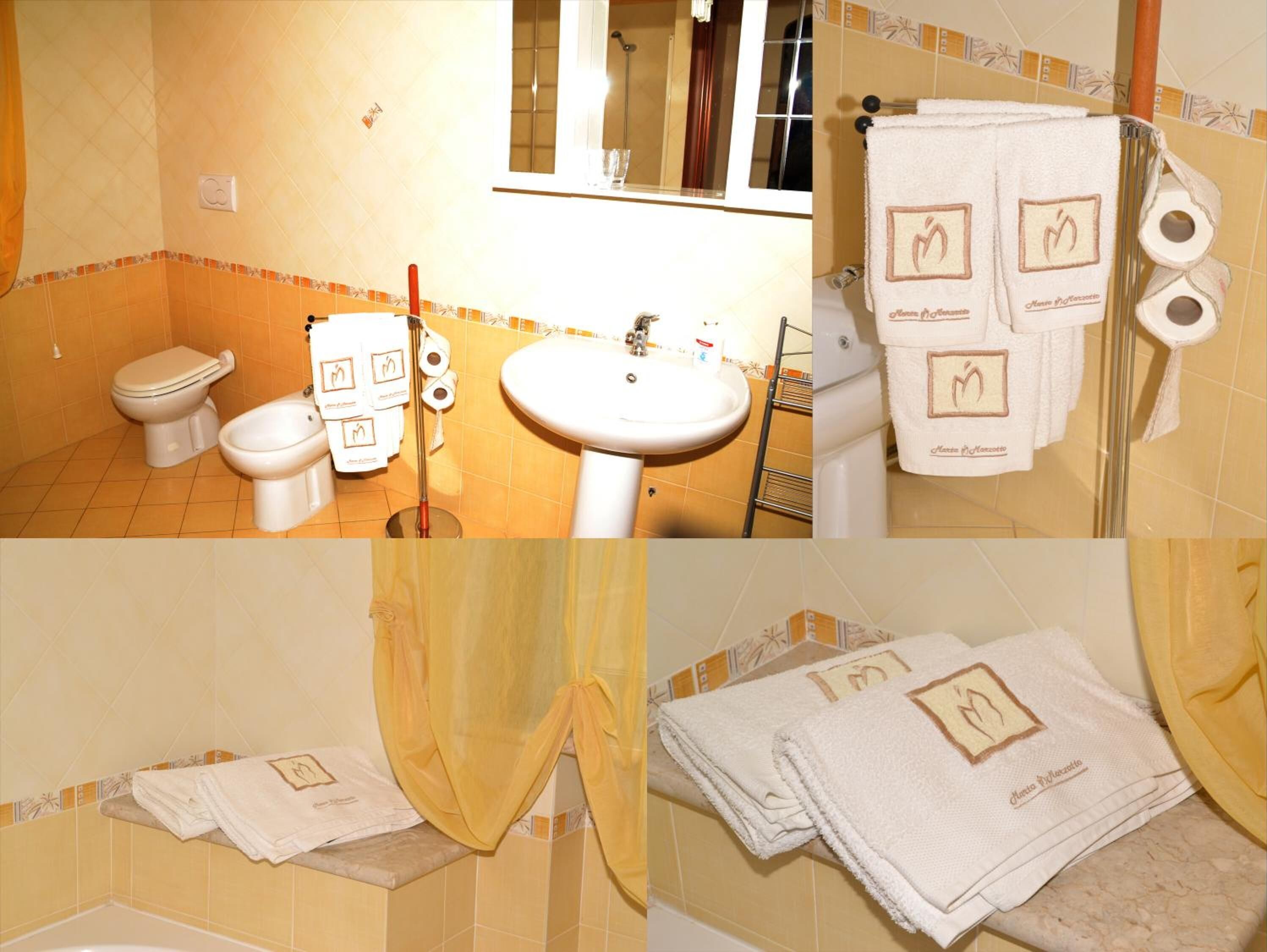 Ein Badezimmer mit Toilette, Bidet, Waschbecken und Handtuchhalter.