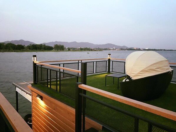 A deck with a grill and seating area overlooking a body of water. - Blue Sky Raft at Kanchanaburi (Kanchanaburi)
