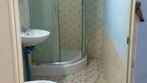 Un baño con ducha, inodoro y lavabo.