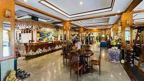 A spacious hotel lobby with a central round table, multiple seating areas, and a reception desk. - Baan Rim Kwai Paerimnam Resort (Sai Yok)