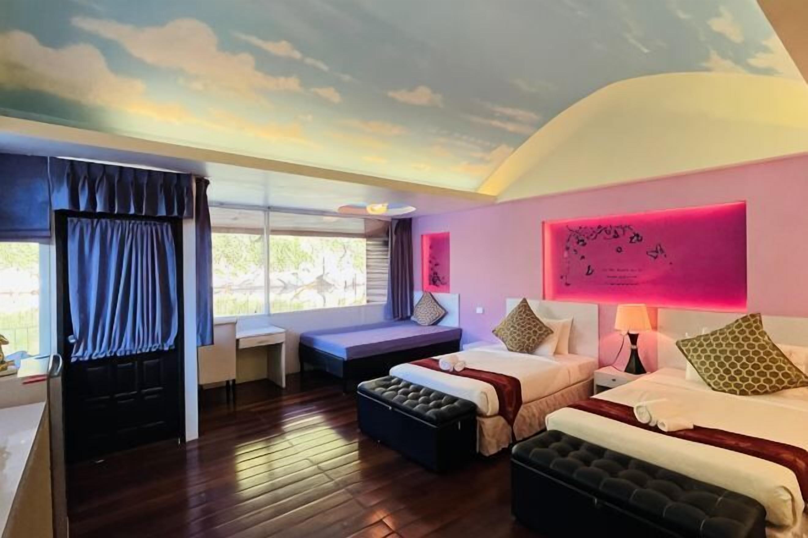 Ein Schlafzimmer mit Bett, Schreibtisch und einem fensterbepflanzten Fenster.