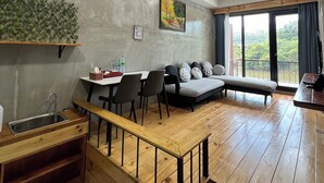 Um espaço de estar moderno com  área de jantar, sofá e vista para um rio.