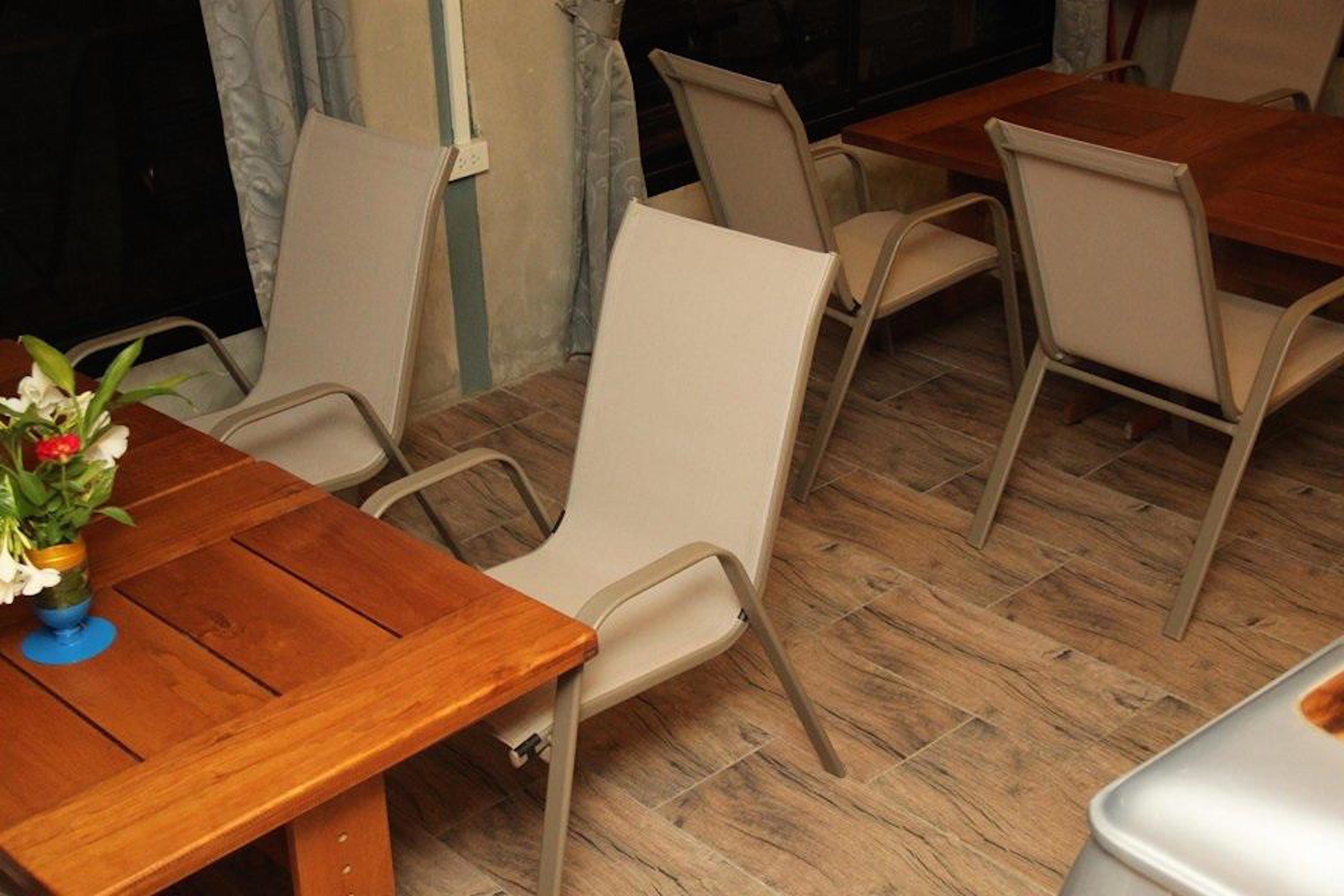 En matplats med bord i trä och stolar i beige färg.
