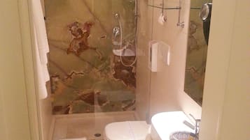 A bathroom with a shower, toilet, and sink.