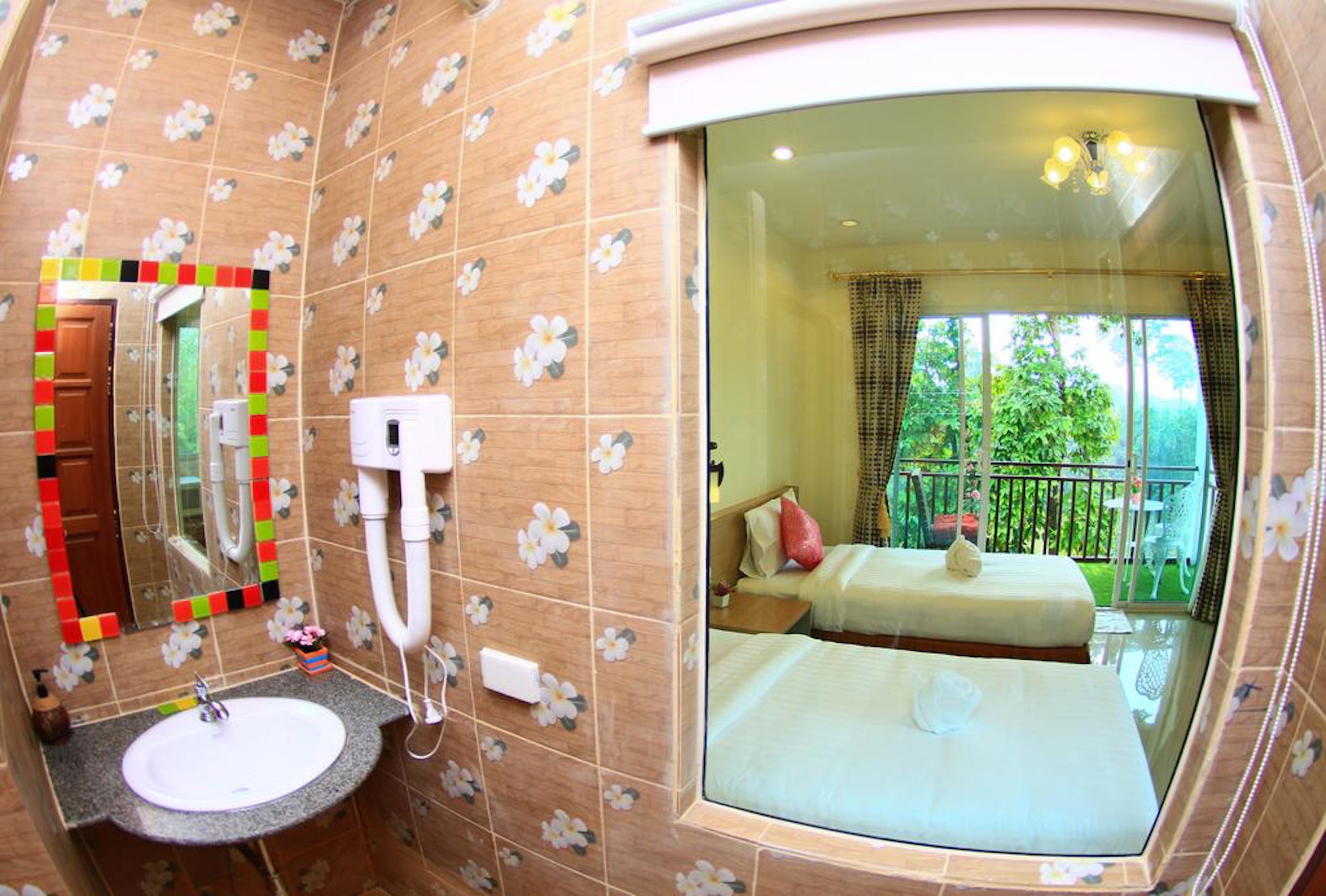 A bathroom with a sink, mirror, and shower.