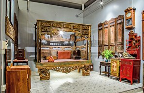 A room with a large ornate bed, wooden furniture, and a collection of clocks on the wall. - Yoko River Kwai Resort (Sai Yok)