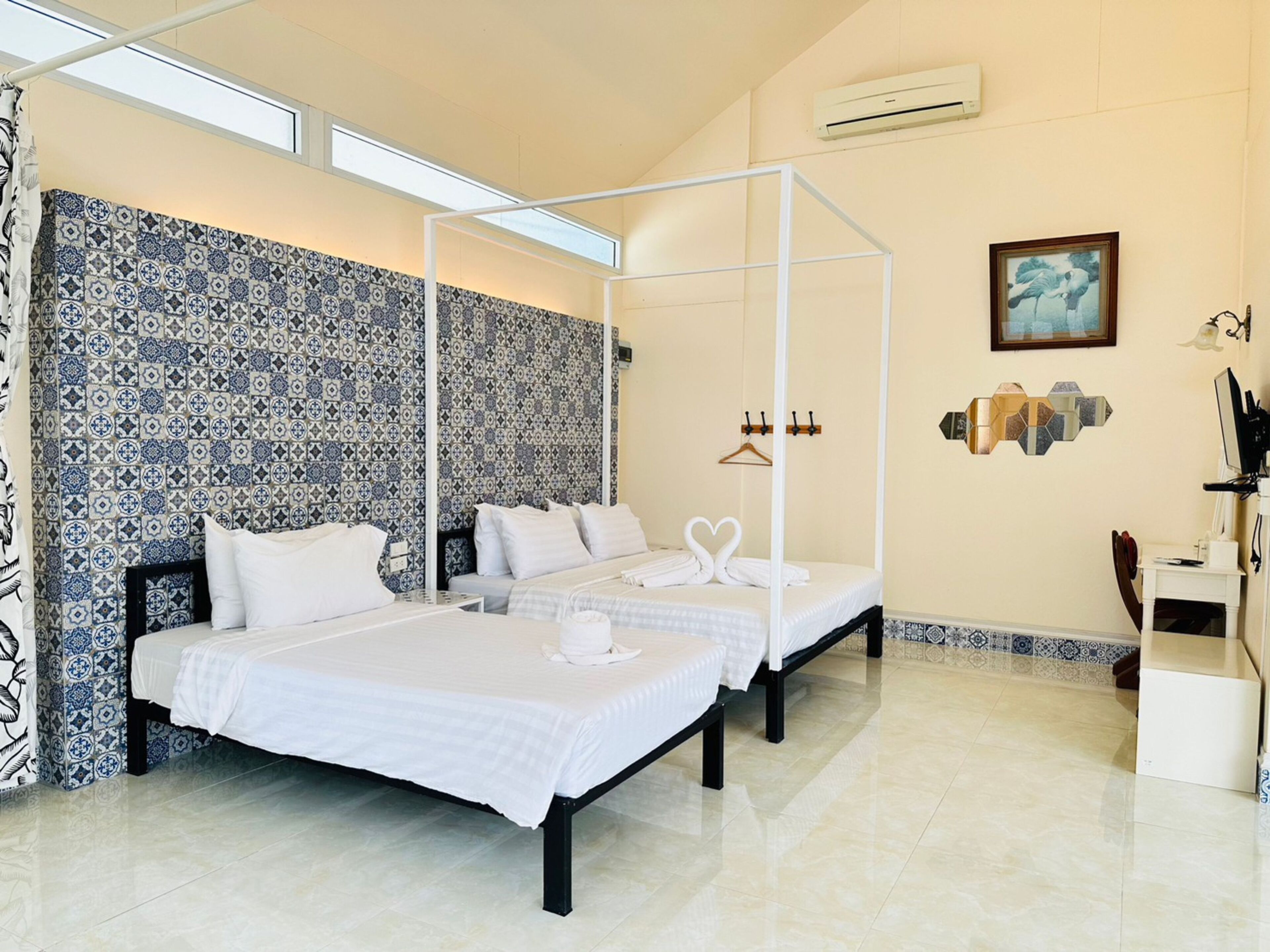 Habitación de hotel con cama, mesita de noche, armario, perchero y aire acondicionado de pared.