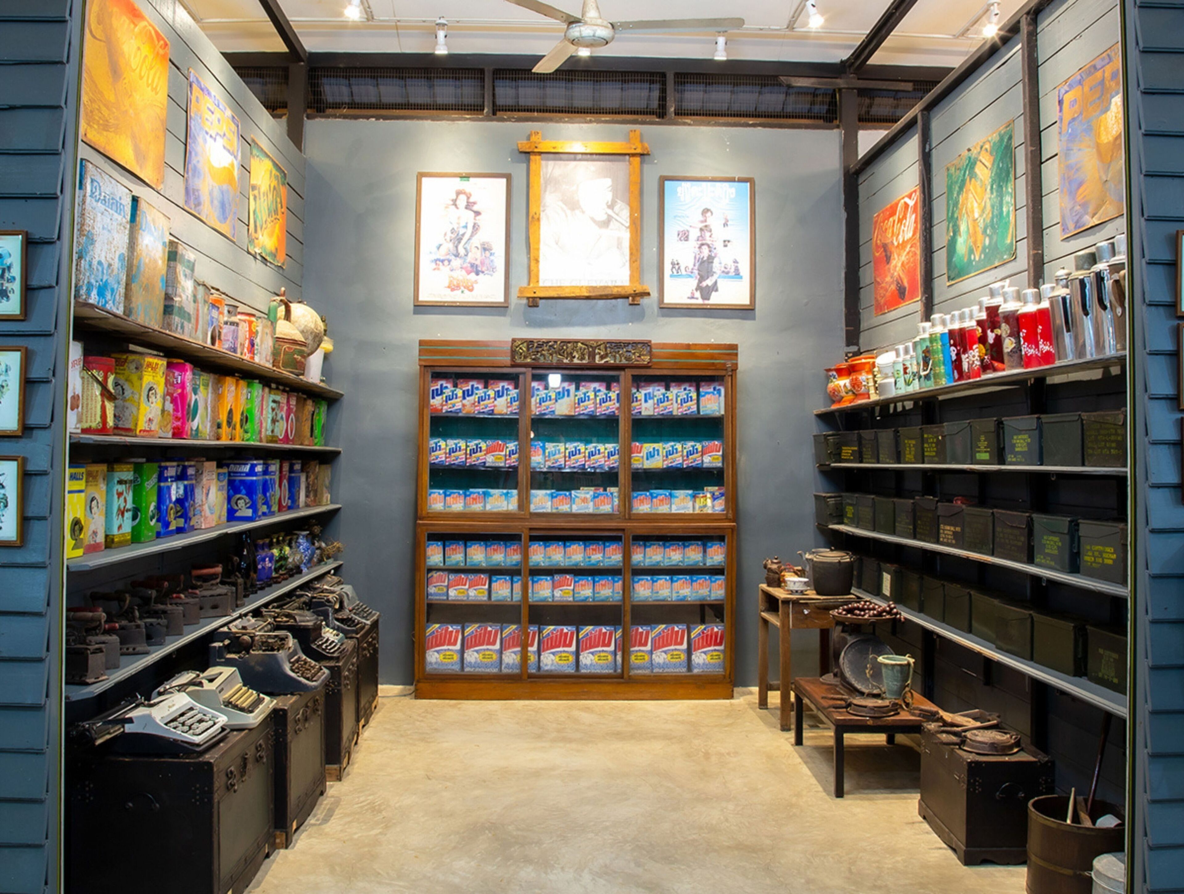A store with shelves stocked with various products, a display of boxed items, and framed pictures on the walls.