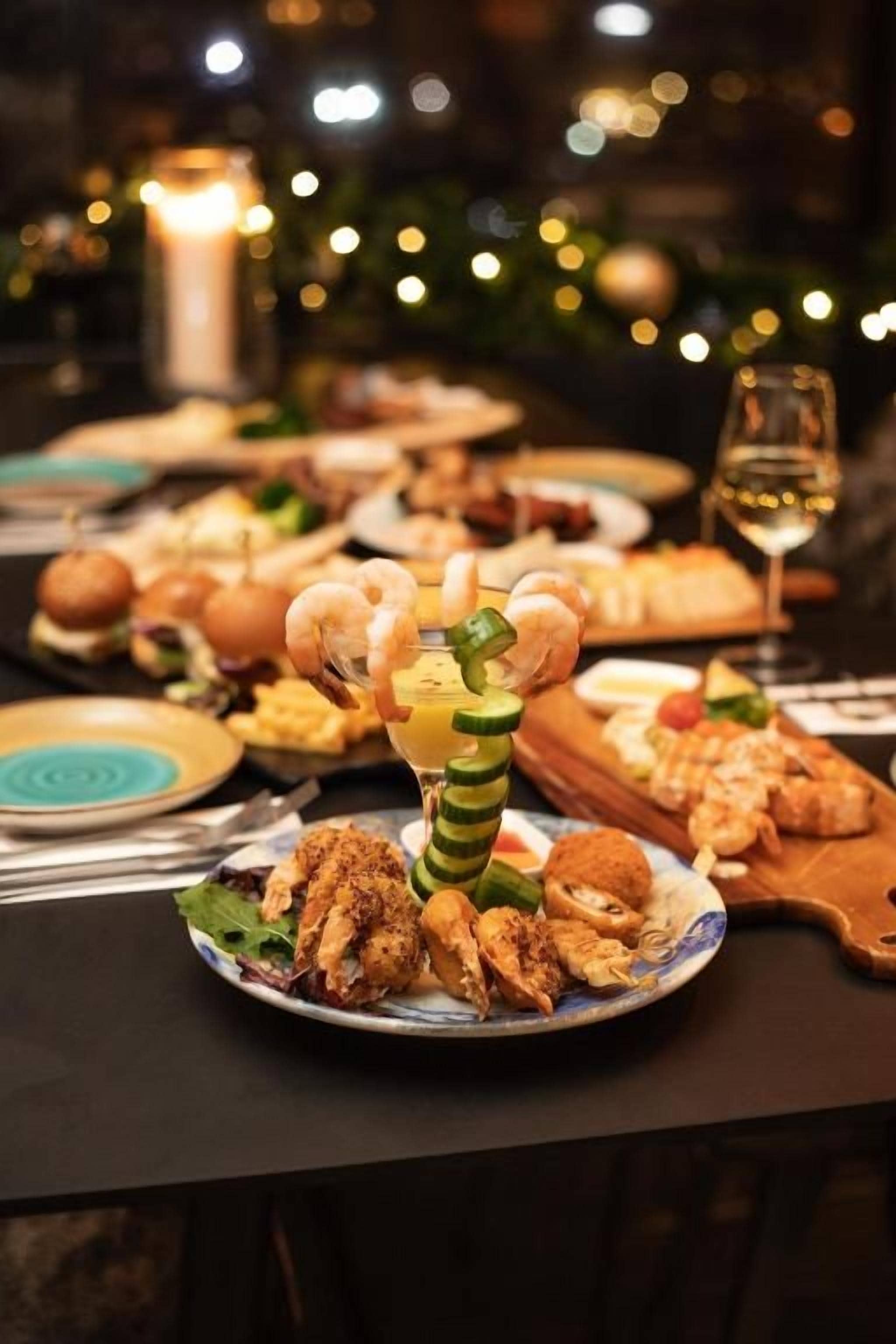 Una mesa de comedor con diferentes platos y una copa de vino.
