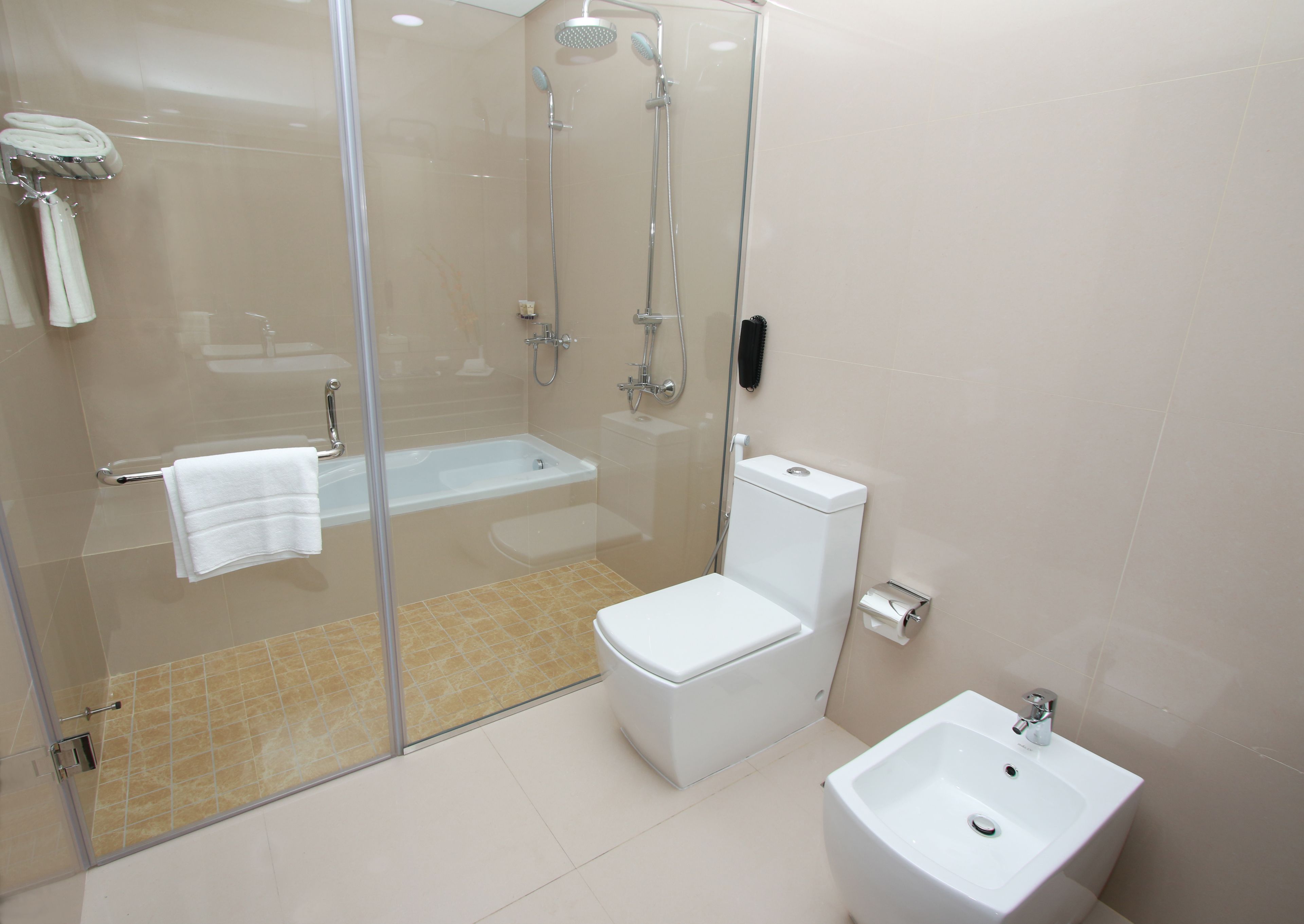 Un baño moderno con ducha acristalada, inodoro y lavamanos.