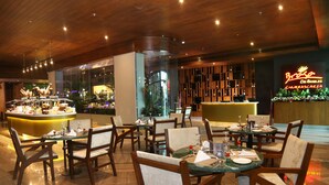 A restaurant with wooden furniture, a bar area, and a neon sign. - Park Regis Lotus Hotel (Manama)