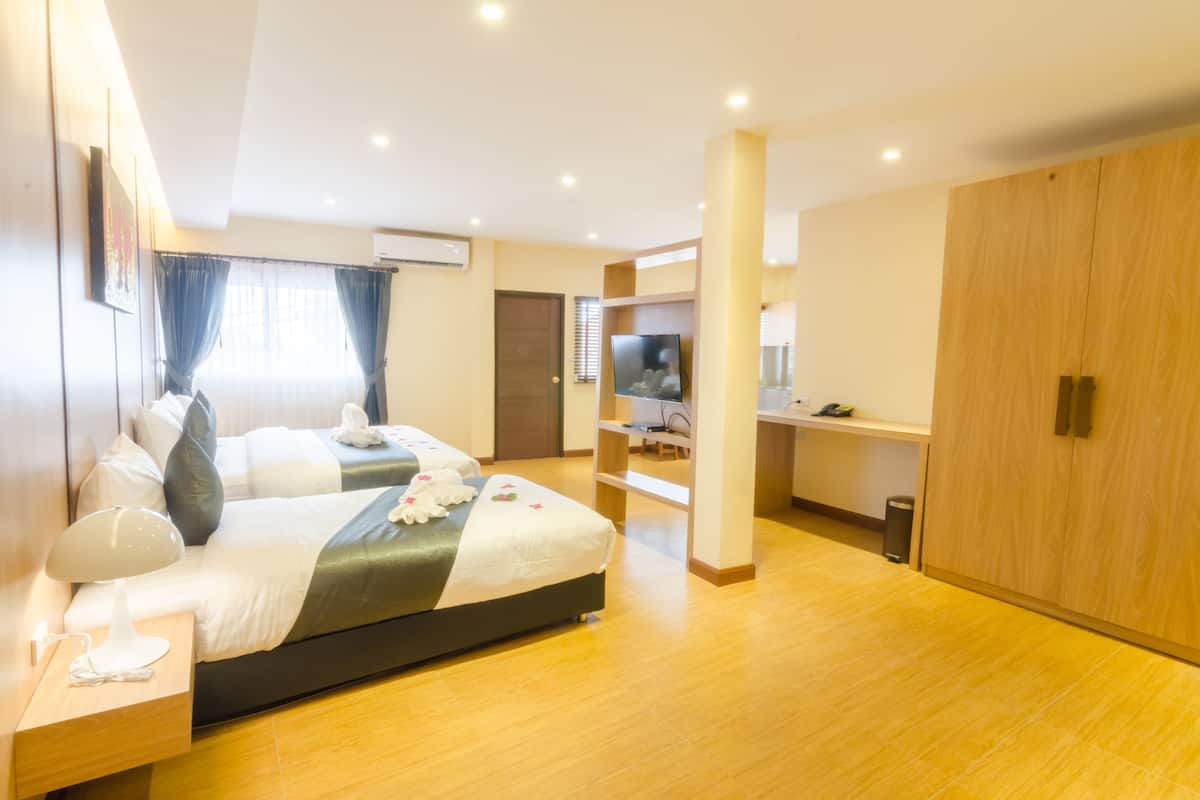 Una habitación de hotel moderna con una cama grande, un escritorio y un armario.