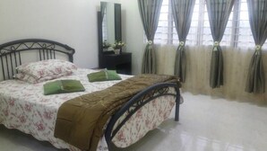 Une chambre Ă coucher avec un lit, une table de chevet, un miroir et des rideaux.