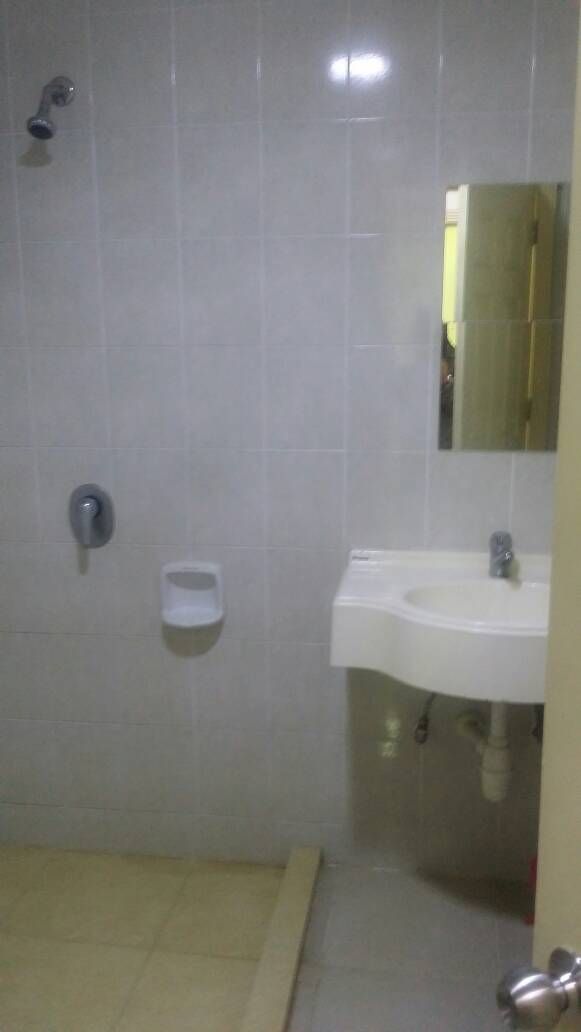 A bathroom with a white sink, a mirror, and a shower area.
