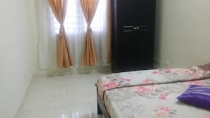 Une chambre à coucher avec un lit, une armoire et une fenêtre avec des rideaux.