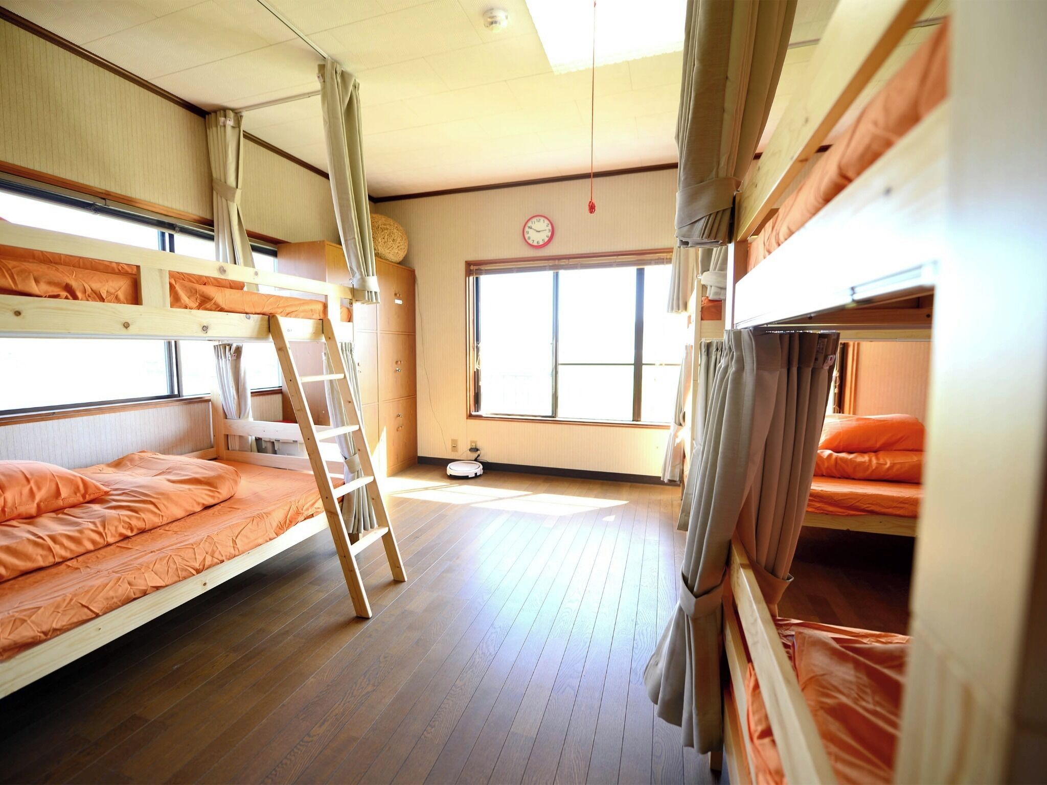 A bunk bed room with a ladder, a window, and a clock on the wall.
