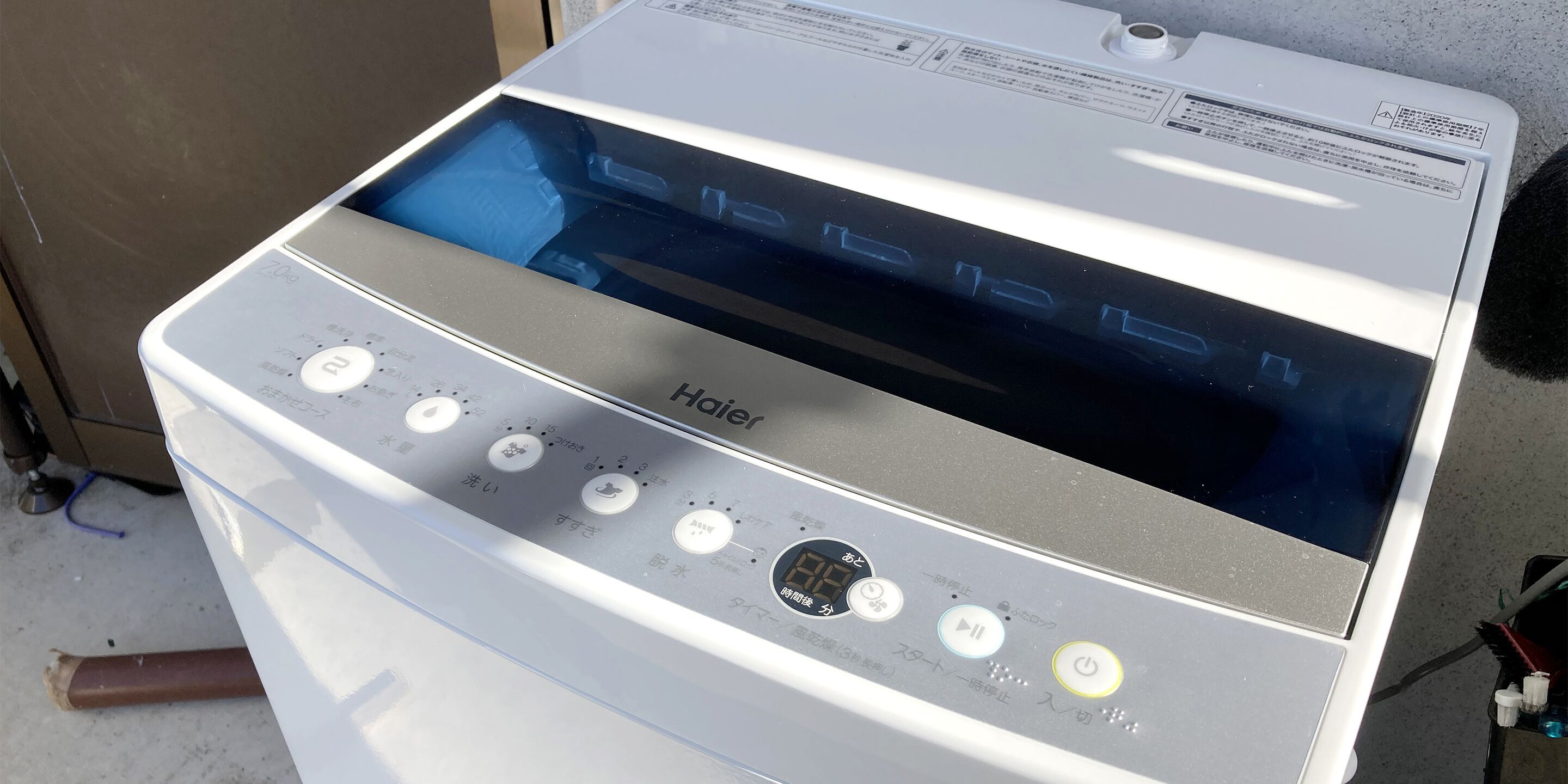 Una estufa eléctrica Haier blanca con pantalla digital y varios botones de control.