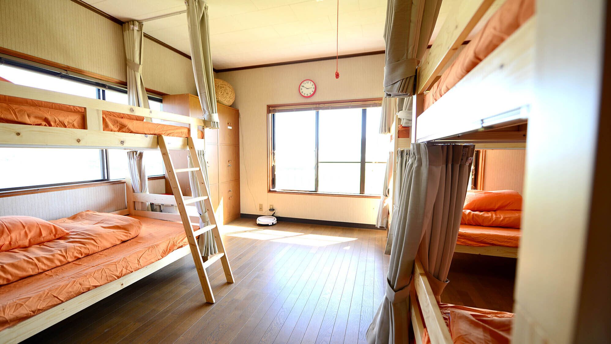 A bunk bed room with a ladder, a clock, and a window.