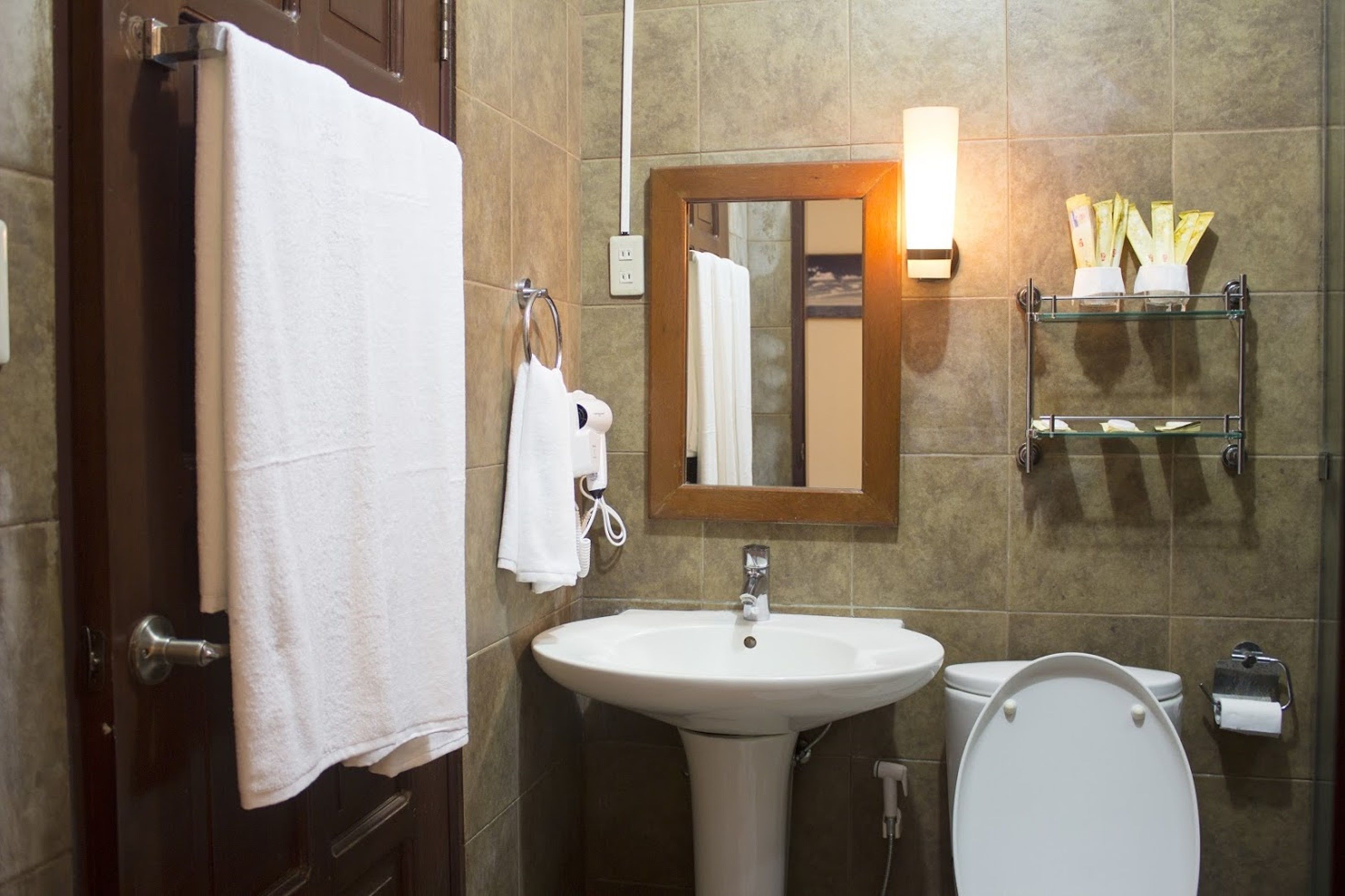 A bathroom with a sink, toilet, and towel rack.