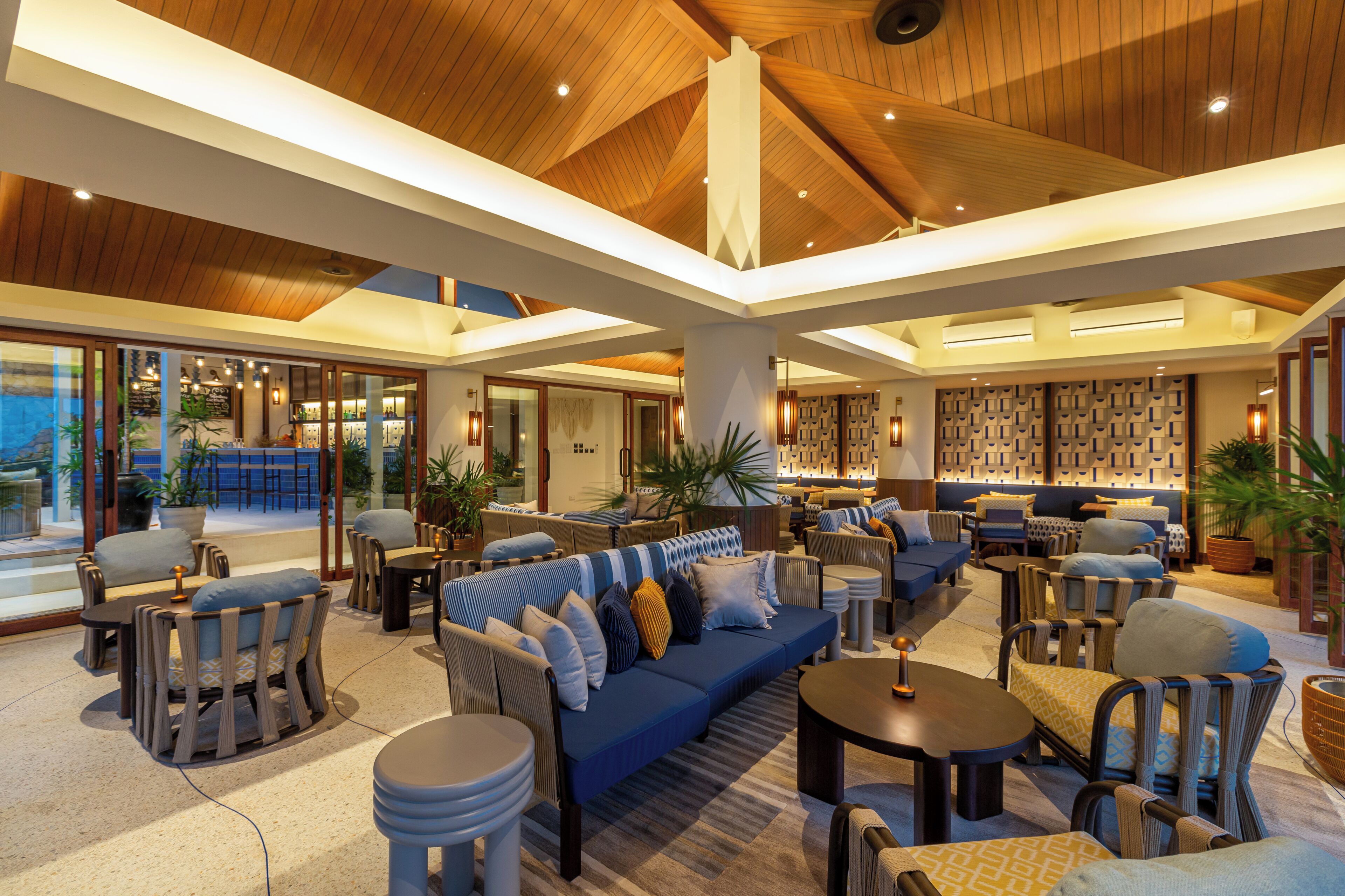 A spacious lounge area with multiple seating options, including sofas and chairs, arranged around a central coffee table.