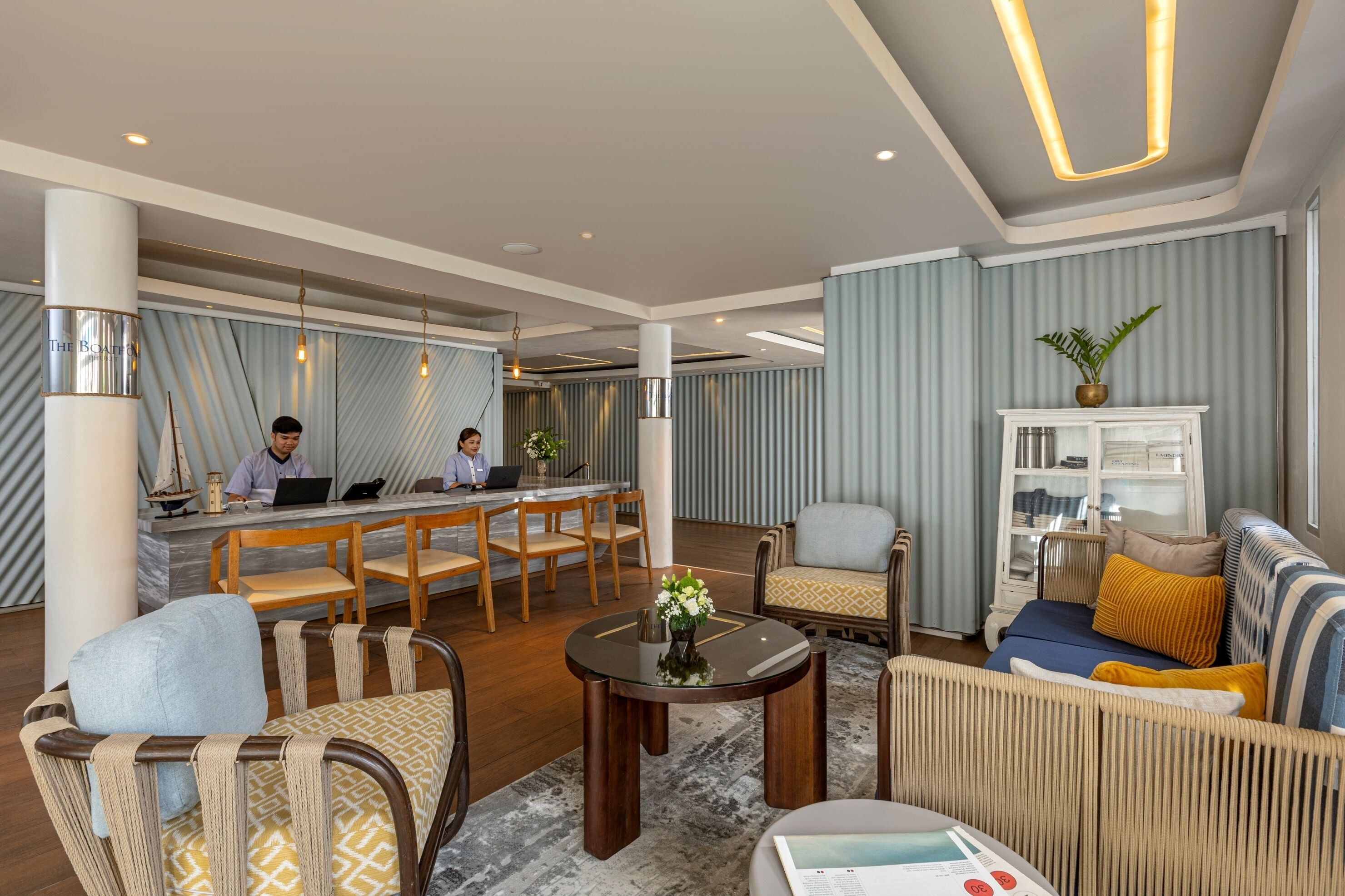Un moderno vestíbulo de hotel con un mostrador de recepción, zona de estar y un bar.