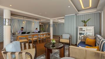 Un moderno vestíbulo de hotel con un mostrador de recepción, zona de estar y un bar.