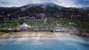 Um resort costeiro com acesso direto à praia, área de piscina e diversos edifícios, incluindo hotéis e estruturas residenciais.