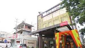 A building with a sign for 'Ronald & Co. Ltd.' and a 'Weddingz.in' sign. There are parked vehicles and motorcycles in front. - OYO 8902 Hotel Ronald Inn (Faridabad)