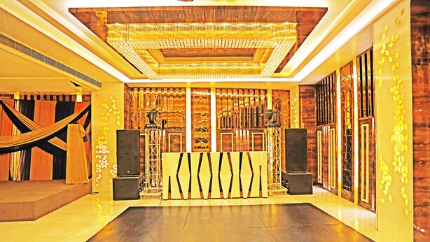 A spacious lobby with a central stage, a patterned wall, and a large chandelier. - OYO 8902 Hotel Ronald Inn (Faridabad)