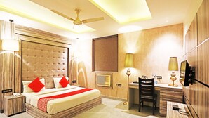 A hotel room with a large bed, a desk, and a chair. - OYO 8902 Hotel Ronald Inn (Faridabad)