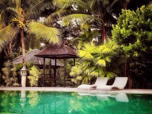 A pool area with lounge chairs, a gazebo, and tropical vegetation. - Mae Nai Gardens (Mae Rim)