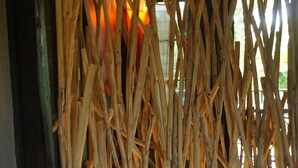 Une pièce avec un lit, une couverture à motifs et une structure murale en bois.
