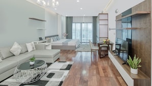 A modern living room with a sofa, coffee table, TV, and a dining area with a table and chairs.