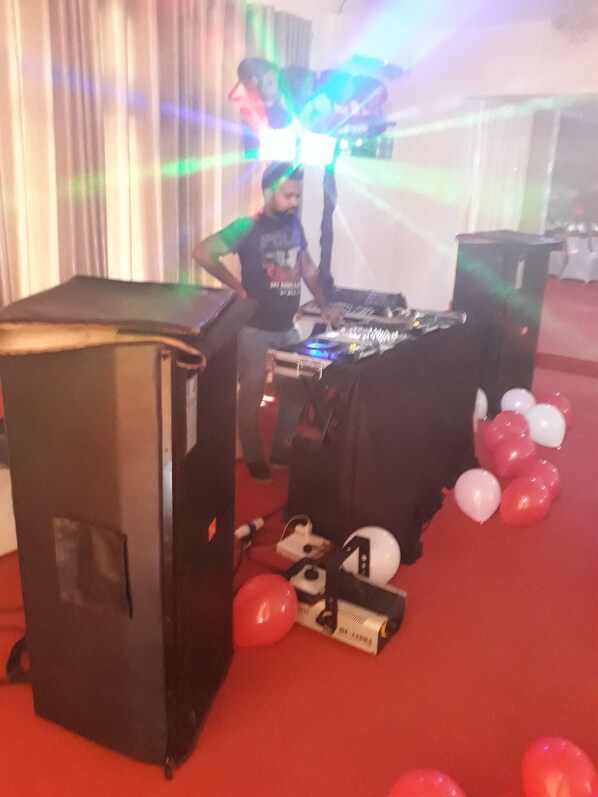 A DJ booth with electronic equipment, balloons, and a large speaker. - The Kingston hotel (Kiribathgoda)