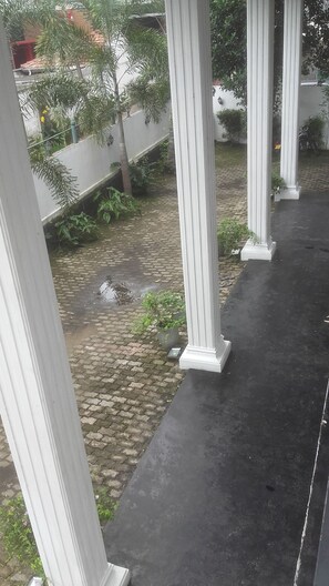 A covered outdoor area with a cobblestone path and a small water feature. - The Kingston hotel (Kiribathgoda)