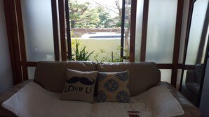 A room with a sofa and a window with frosted glass.