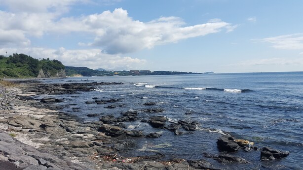A rocky shoreline with waves crashing onto the rocks.