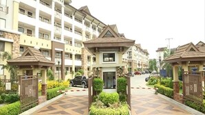 Un edificio residencial de varios pisos con una entrada protegida por una reja y un patio central.
