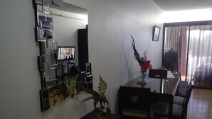 Un comedor con una mesa, sillas, un jarrón con flores, un libro y un objeto decorativo.